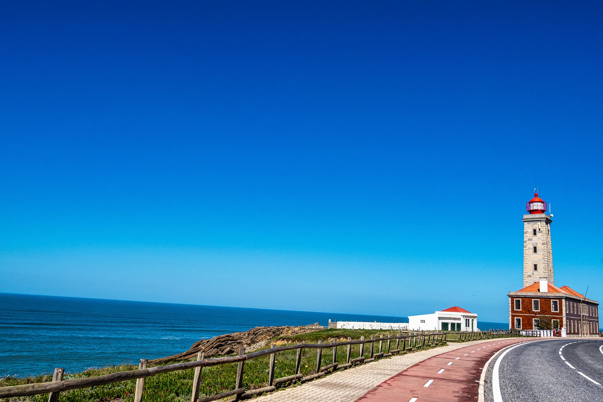 Penedo da Saudade Lighthouse in Marinha Grande by the blue ocean under a clear sky.
