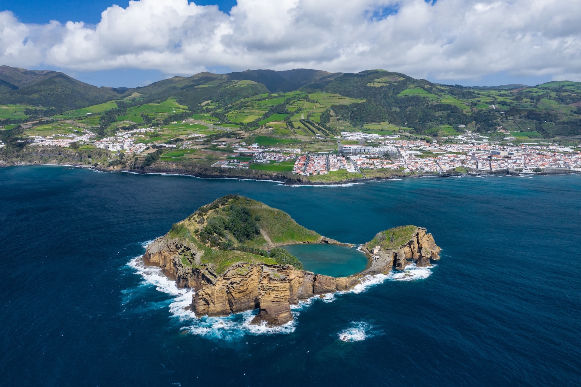 Aerial view of Islet of Vila Franca do Campo with natural pool and green hillsides.