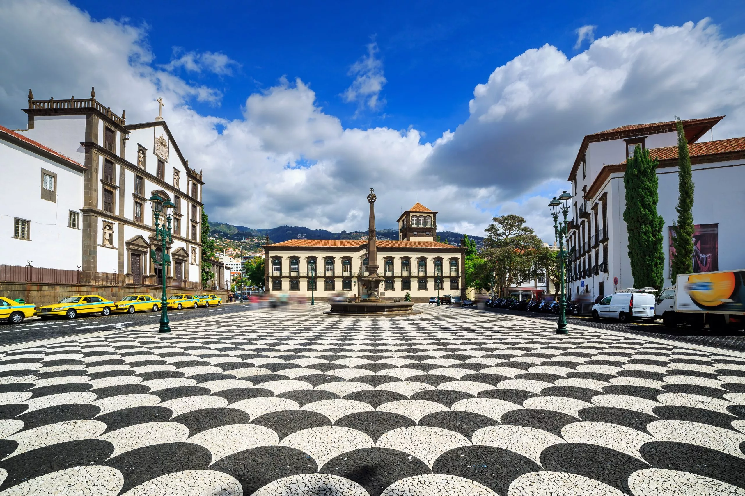Beautiful cityscape of the townsquare Praca do Municipio in Funchal, Madeira, with the Church of St. John the Evangelist and the city hall, on a summer day with blue sky and clouds